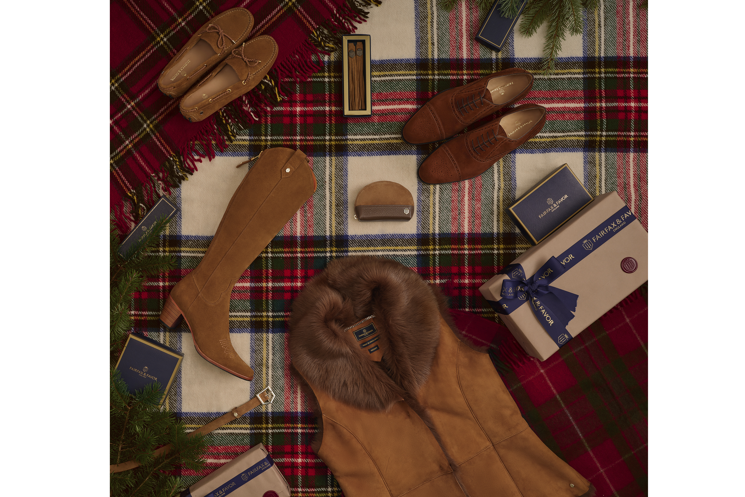 Flat lay photo shoot with shoes handbags and Christmas presents laying down on a tartan rug